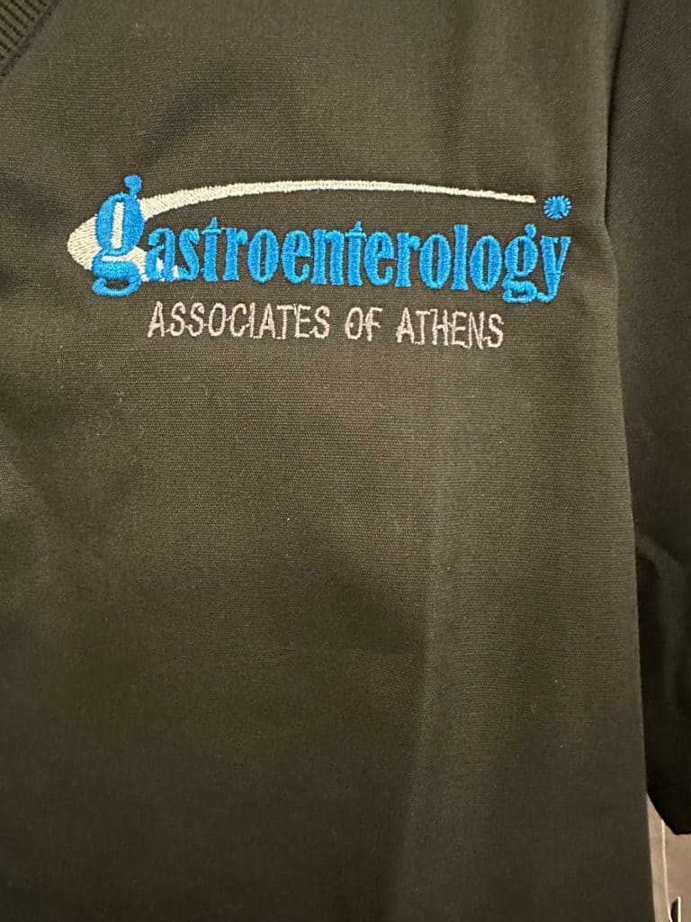 Gastroenterology embroidered logo on a dark fabric, featuring blue and white threadwork.