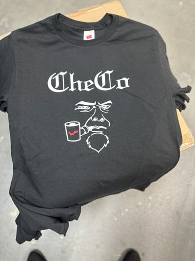 Custom black T-shirt with "The Go" logo and face illustration for silk screen and embroidery.